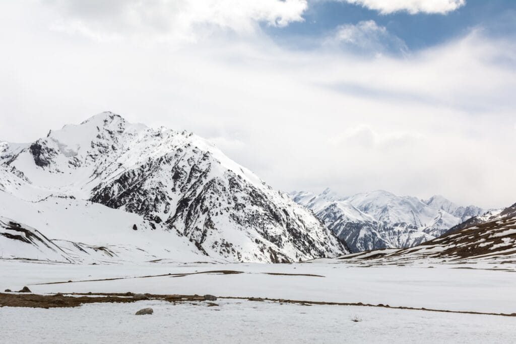 Trekker auf der Schneeflanke unter der Gondogoro La vor Tagesanbruch