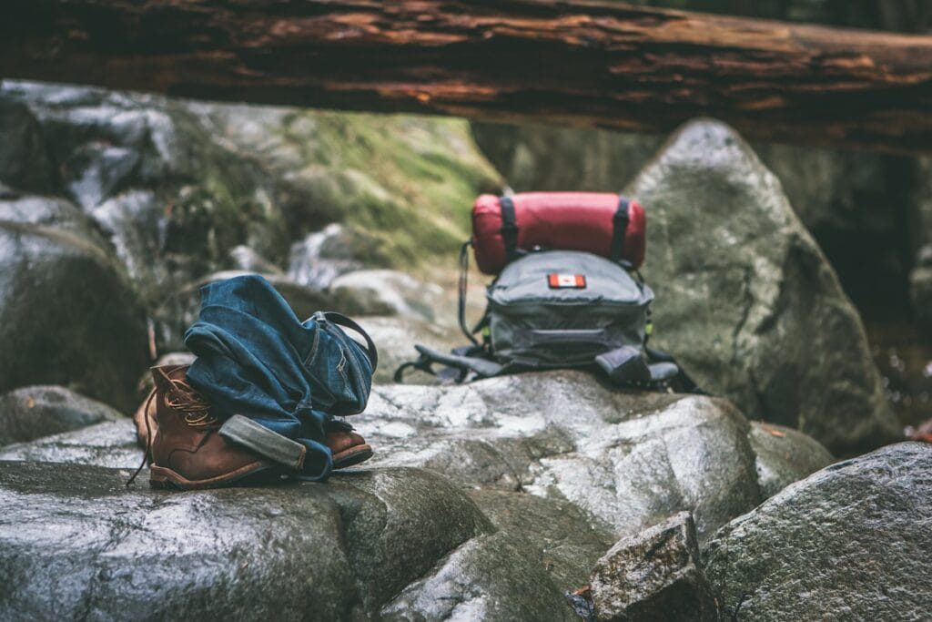 Ausrüstung für einen Karakorum-Trek ausgelegt: Daunenschlafsack, Stiefel, Seesack und Lagen