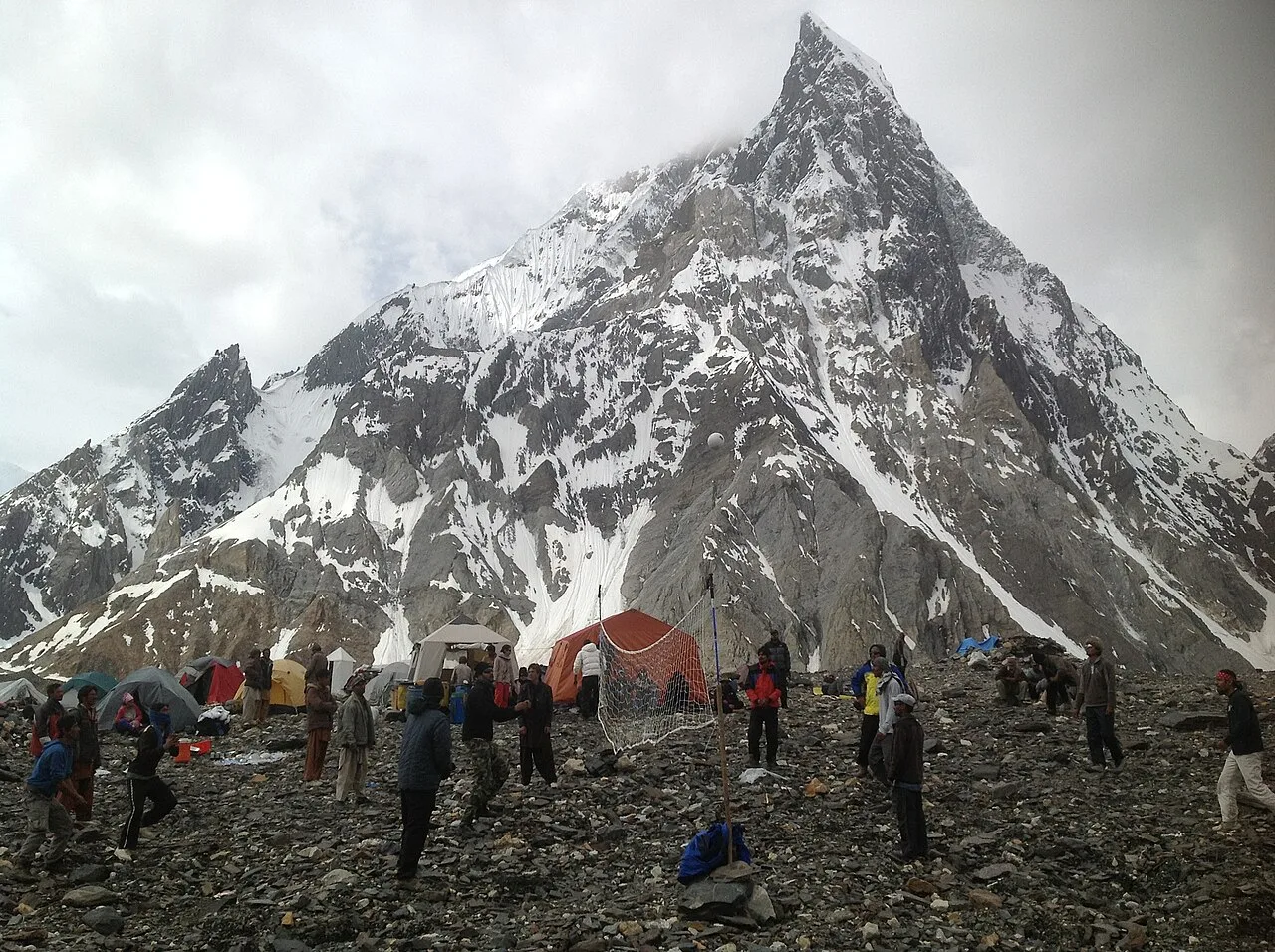 Trekkers tents at Concordia camp on the Baltoro Glacier with the rock spire of Mitre Peak behind, Karakoram, Pakistan
