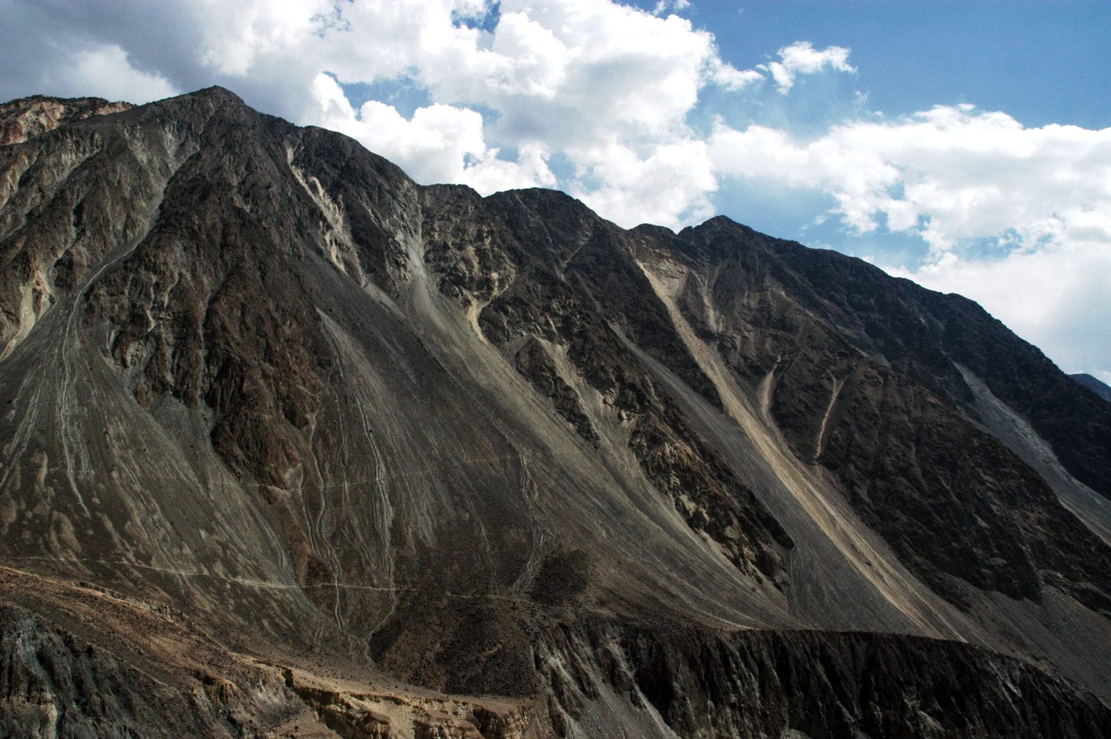 Ripidi versanti montuosi e un conoide alluvionale racchiudono la Valle di Bagrot vicino a Gilgit, Pakistan