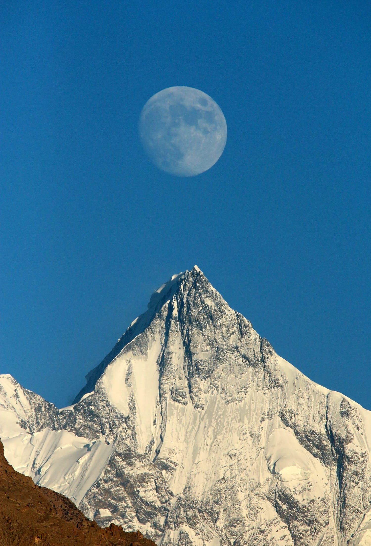 La luna sorge sopra la cima nevosa del Lupghar Sar, vista da Aliabad, Hunza