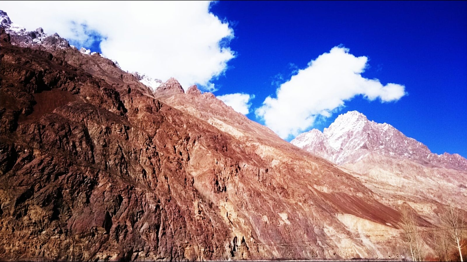 Steep rock and snow wall rising above the Shimshal valley in Hunza District