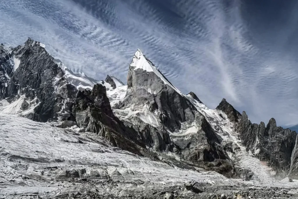 Sommet de roche et de neige coiffé d'un nuage lenticulaire