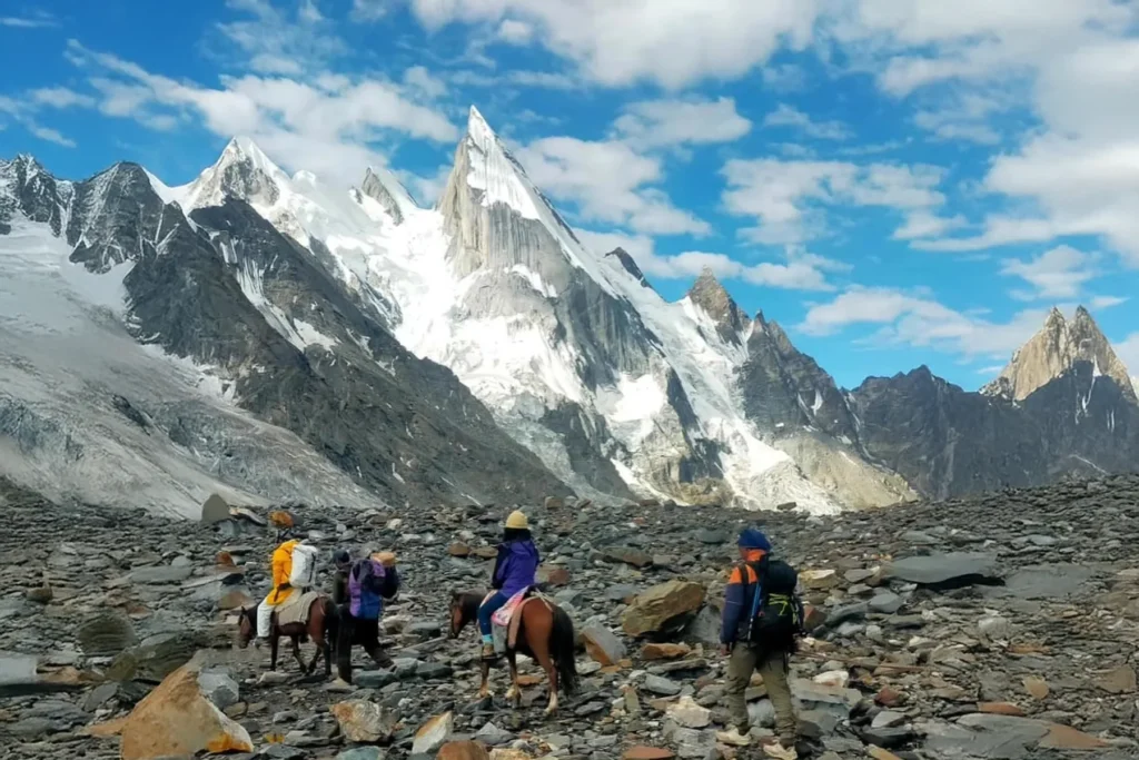 Mazeno Pass trek group with pack horses crossing a moraine field